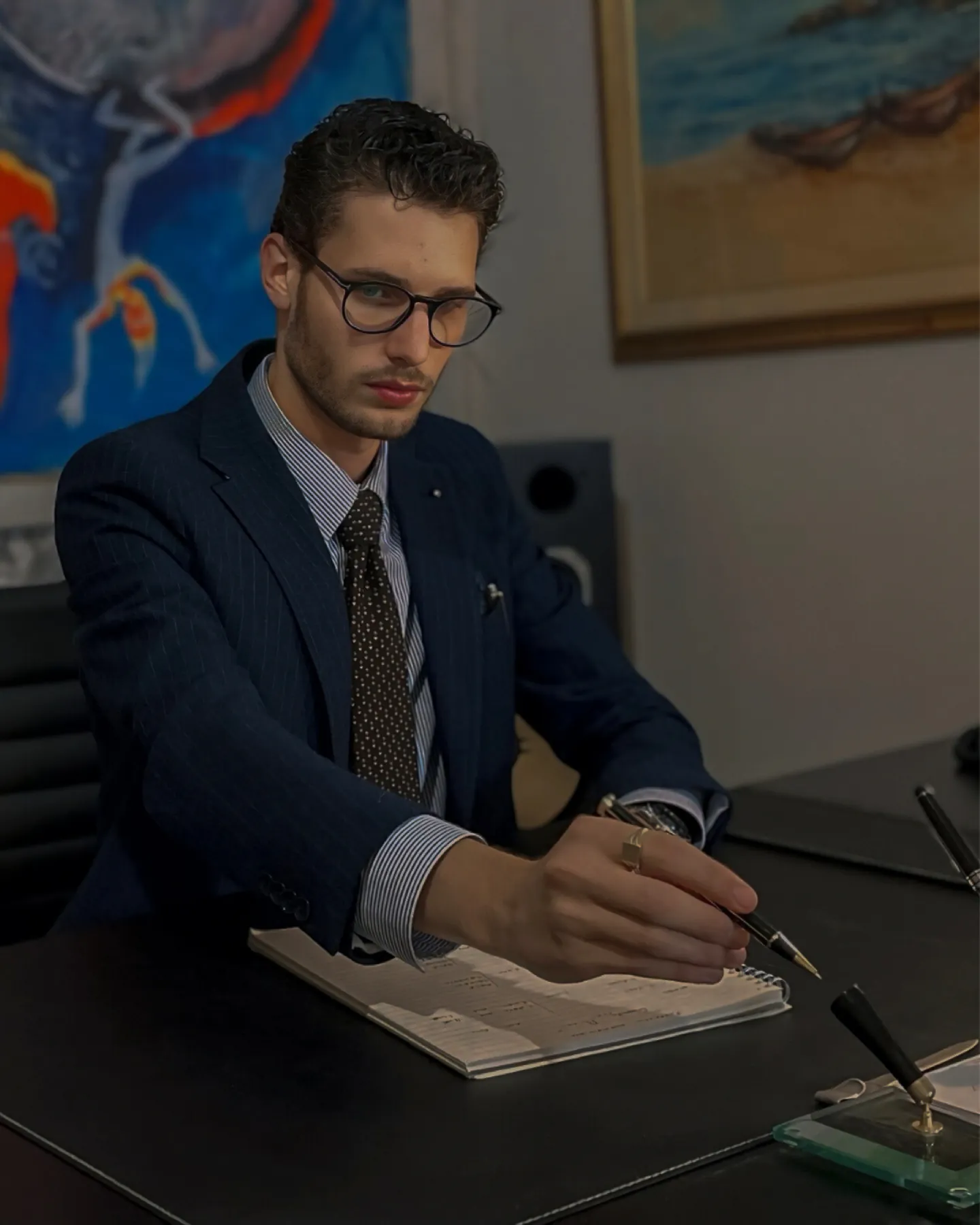Patrick Liverani alla scrivania mentre prende appunti, in giacca blu